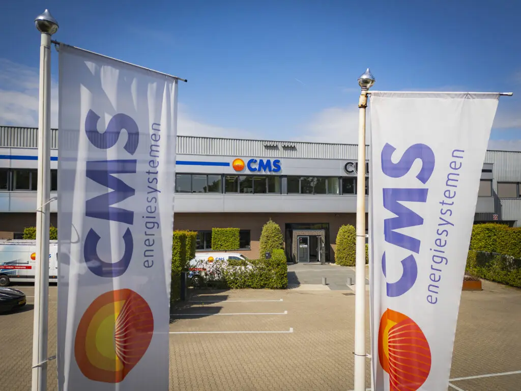 Pand CMS energiesystemen met op de voorgrond de vlaggen