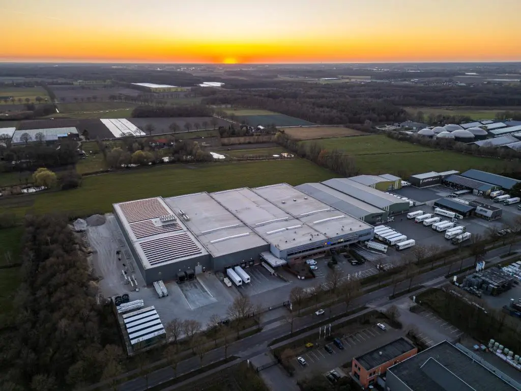 Bovenzijde pand Cuppen Logistics met zonnepanelen en vrachtwagens op het voorterrein